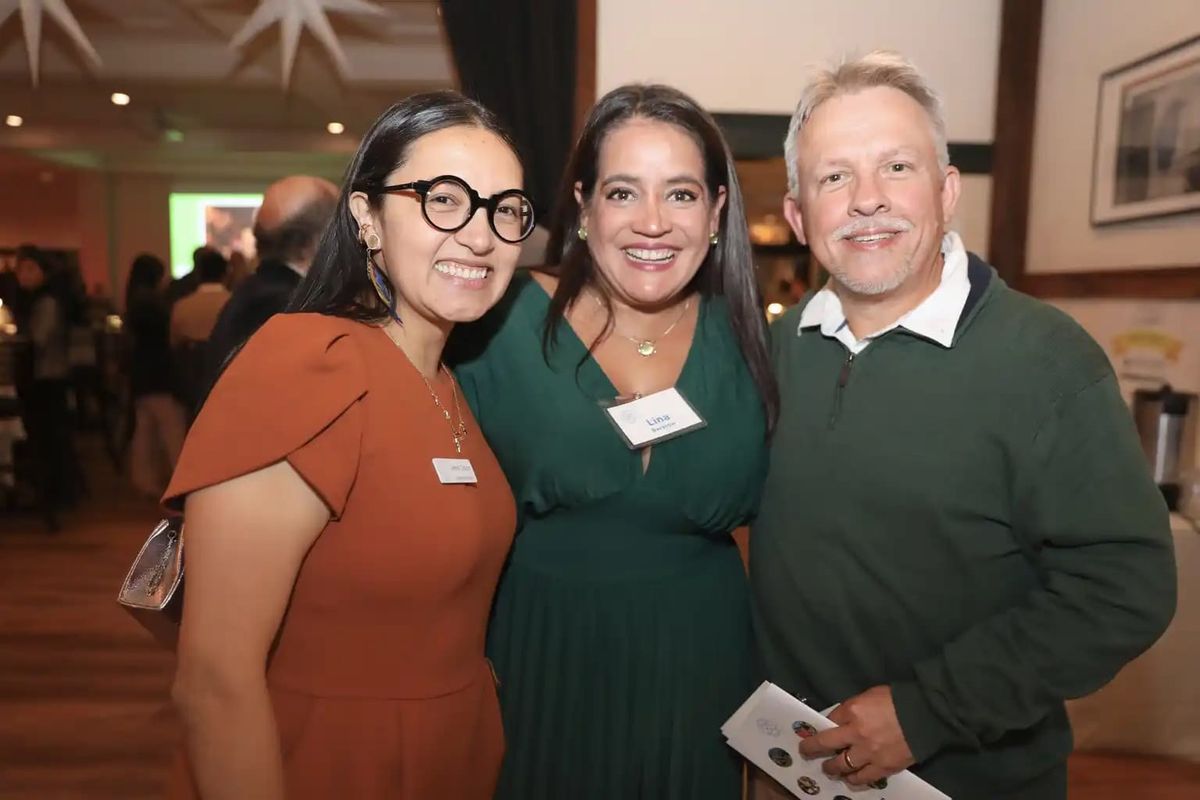 Three guests smiling together at LitNet's annual celebration at Barrington Hall